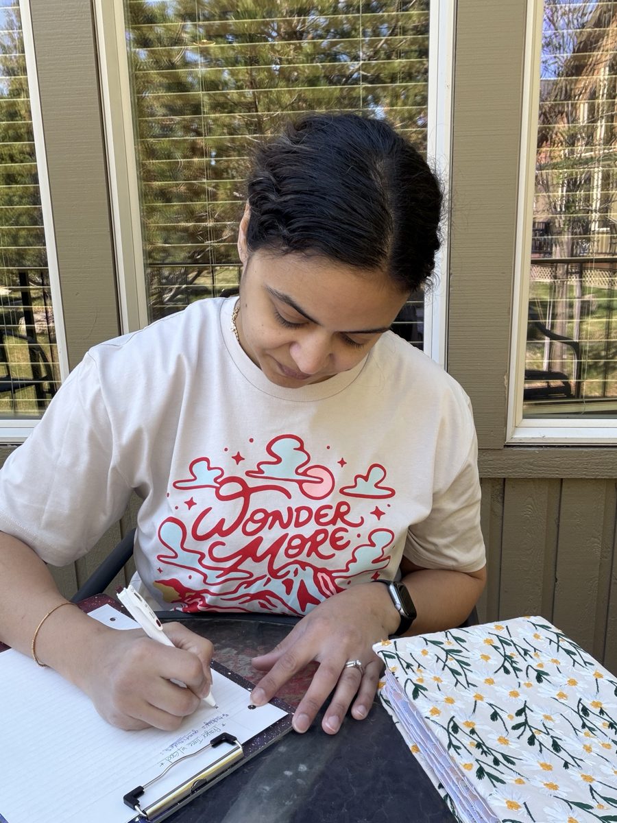 Sabrina journaling at her patio table